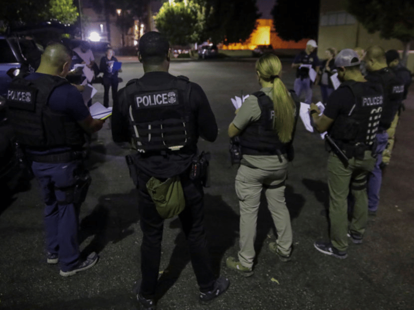 Los Angeles, CA - September 08: Immigration and Customs Enforcement agents huddle in a par