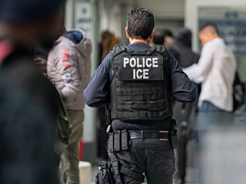 NEW YORK, NEW YORK - JUNE 6: An ICE agent monitors hundreds of asylum seekers being proces