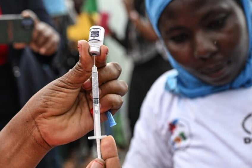 A nurse prepares a dose of a vaccine against malaria on the first day of a vaccination dri