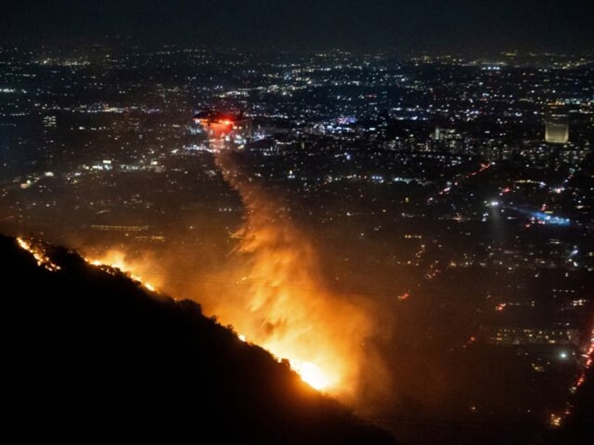 Water is dropped by helicopter on the burning Sunset Fire in the Hollywood Hills section o