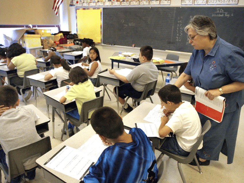 Teacher Arlene Lebowitz assists a student in her third-grade class during summer school Ju