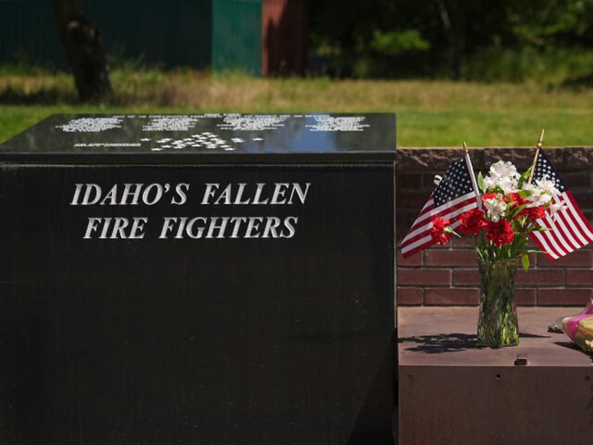 Flowers are seen at the Fallen Heroes Plaza at Cherry Hill Park near the scene the day aft