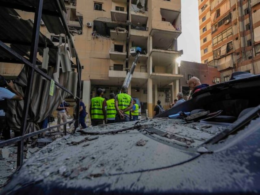 Rescuers check a building that was hit by an Israeli airstrike in Beirut's southern s