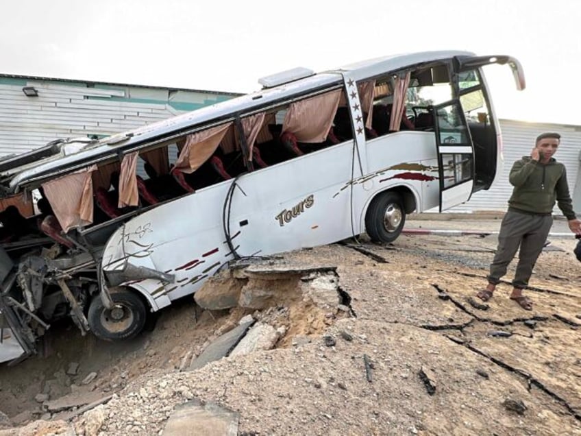 A bus sits inside a crater following an Israeli strike in Khan Yunis in the southern Gaza