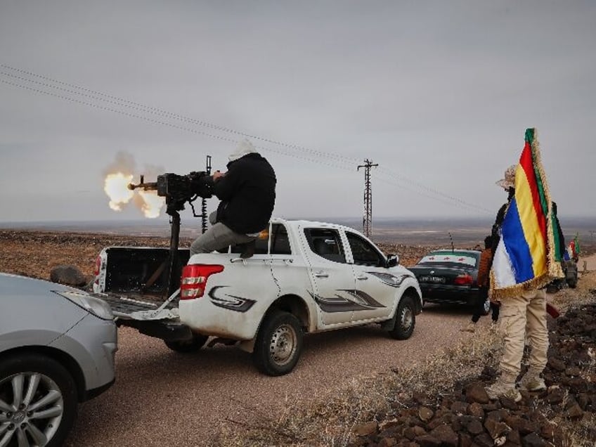 A Druze militiaman fires from a machine-gun attached on the back of a truck during a shoot