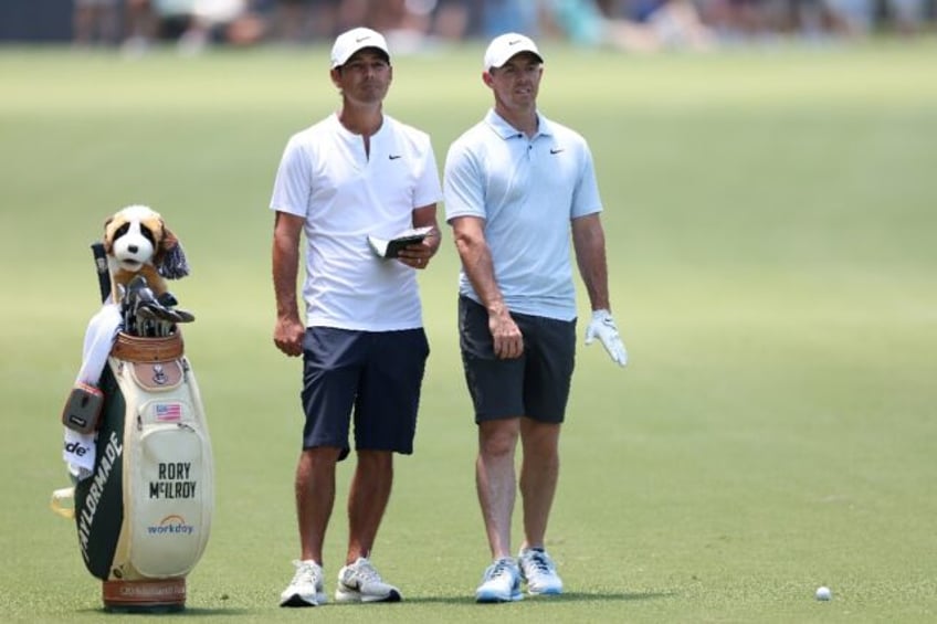 Four-time major winner Rory McIlroy, right, and his caddie Harry Diamond prepare for a sho