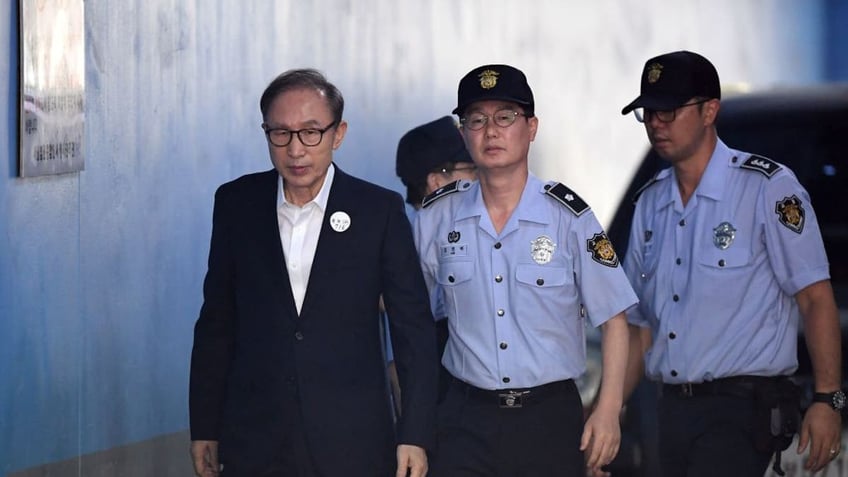 Former South Korean president Lee Myung-bak (L) arrives at a court to attend his trial in Seoul on September 6, 2018. Prosecutors demanded 20 years in prison for former South Korean president Lee Myung-bak for corruption,  the last of the country's four living ex-leaders to be embroiled in a criminal inquiry. J