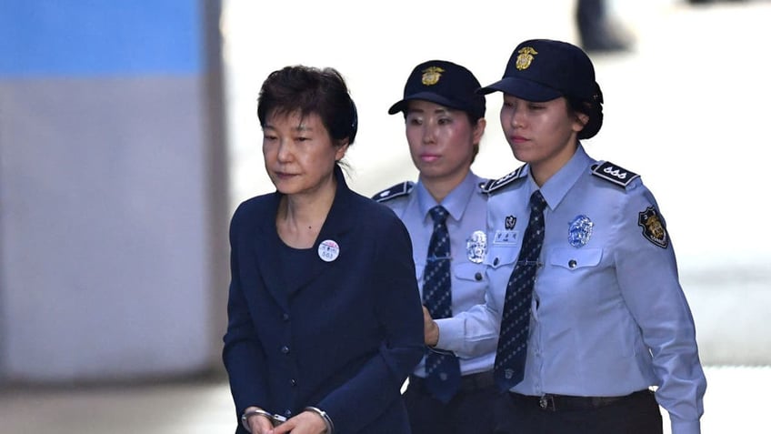 TOPSHOT - South Korean ousted leader Park Geun-Hye (L) arrives at the Seoul Central District Court in Seoul on May 25, 2017, for her trial over the massive corruption scandal that led to her downfall.  