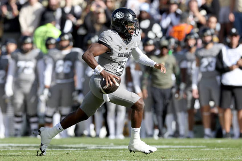 Quarterback Shedeur Sanders of the Colorado Buffaloes carries the ball for a touchdown against the Arizona Wildcats in the first quarter at Folsom...