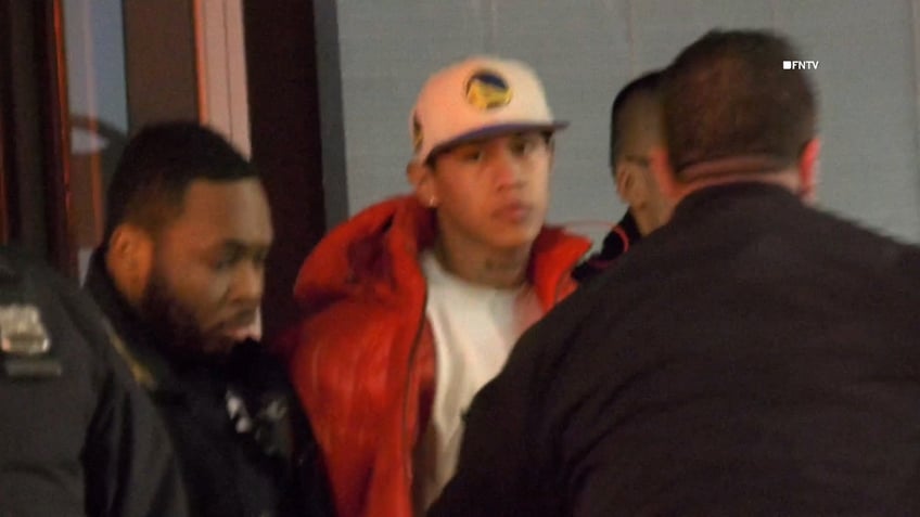 Suspect in orange puffer jacket patted down by NYPD