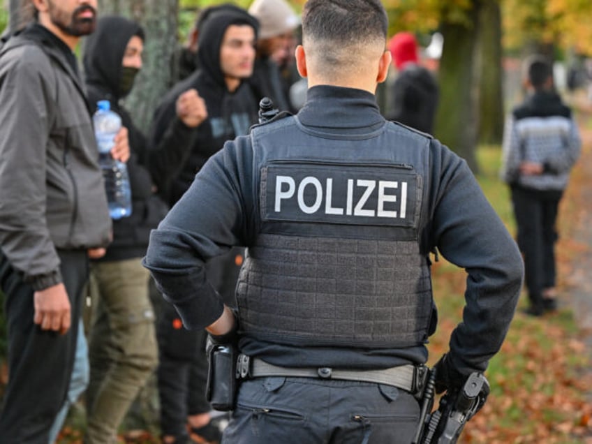 11 October 2023, Brandenburg, Forst: Illegal migrants are guarded by a Federal Police officer during an apprehension near the German-Polish border in Forst (Lausitz). During several operations in Forst, Brandenburg, and the surrounding area, the Federal Police had apprehended at least 64 migrants who had entered the country without permission …