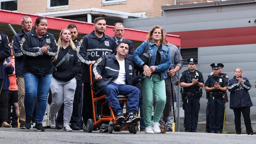 NYPD officer wheeled from hospital with family