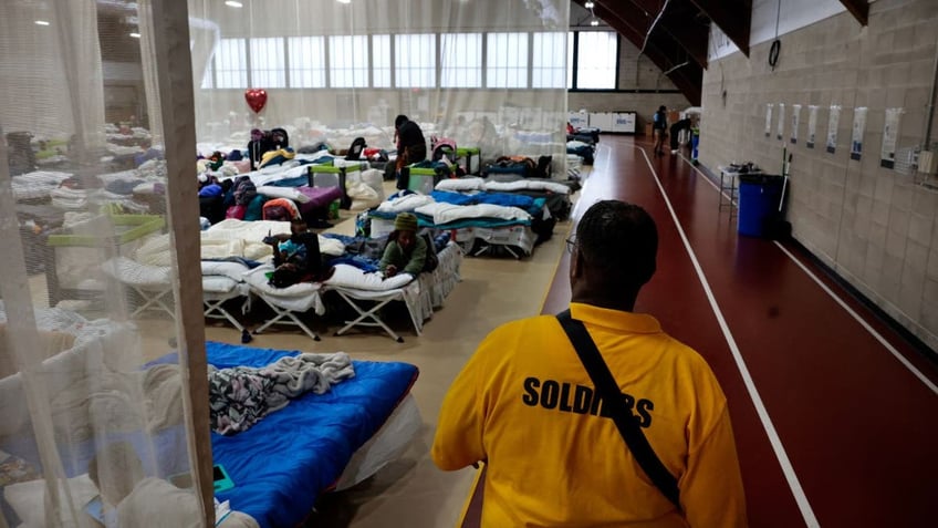 migrant shelter, man in yellow shirt walking