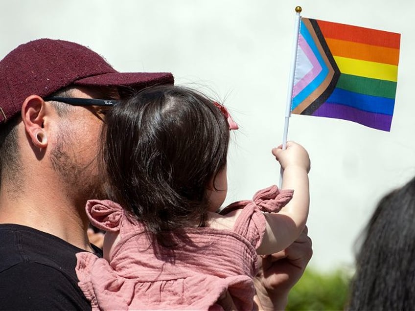 San Fernando, CA - June 01: Louis Salazar hold his daughter Alice, 1-year old, during a Pr