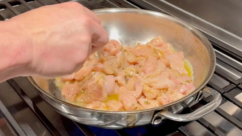 Dr. Jeremy London sautés the chicken he's going to use in his Greek-inspired chicken salad.