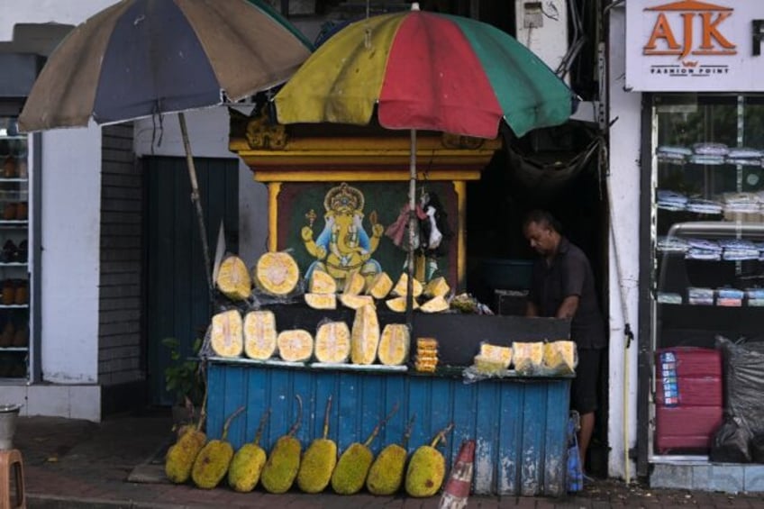 A vendor selling jackfruit waits for customers at a stall in Colombo in September