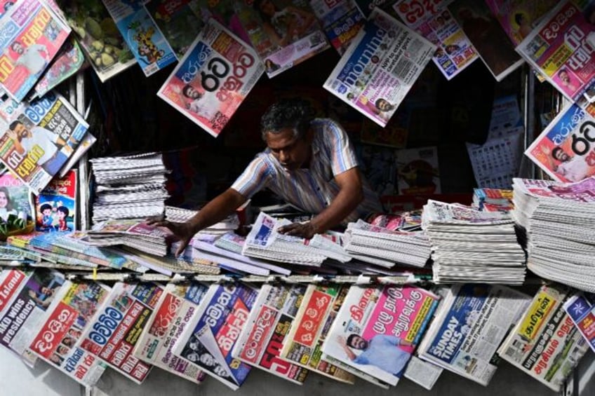 A Sri Lankan newspaper vendor arranges his display on the day the country's new president