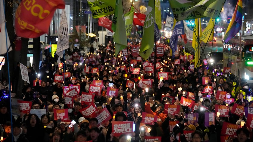 Protesters march to the presidential office after a candlelight vigil against South Korean President Yoon Suk Yeol in Seoul, South Korea, Thursday, Dec. 5, 2024.