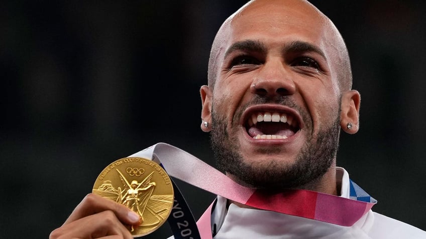 Lamont Marcell Jacobs of Italy poses with his gold medal following the men's 100-meters final at the 2020 Summer Olympics