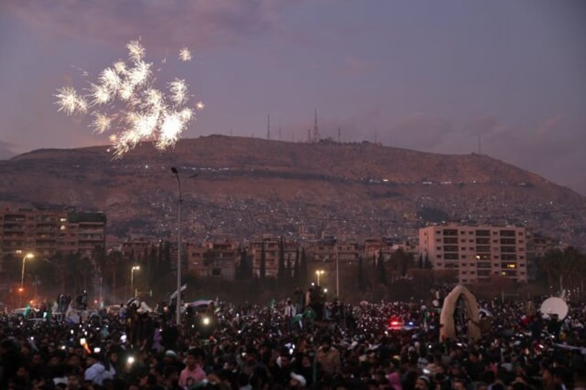 Fireworks errupt as Syrians gather to celebrate the ousting of president Bashar al-Assad a