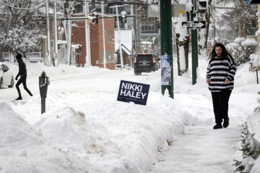 Residents walk by a campaign sing for 2024 presidential hopeful Nikki Haley in Iowa City, Iowa, on January 13, 2024