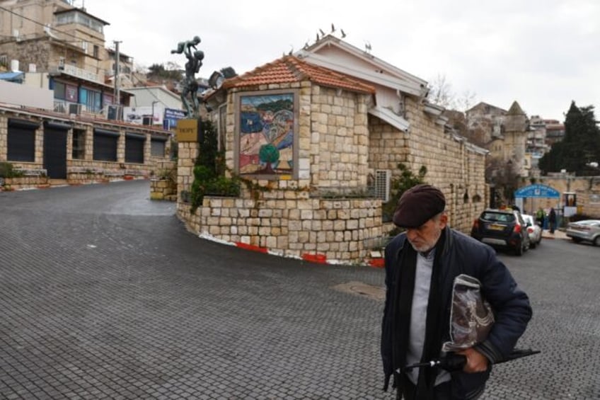 A man walks in an empty alley in Israel's northern city of Safed, amid ongoing cross-borde