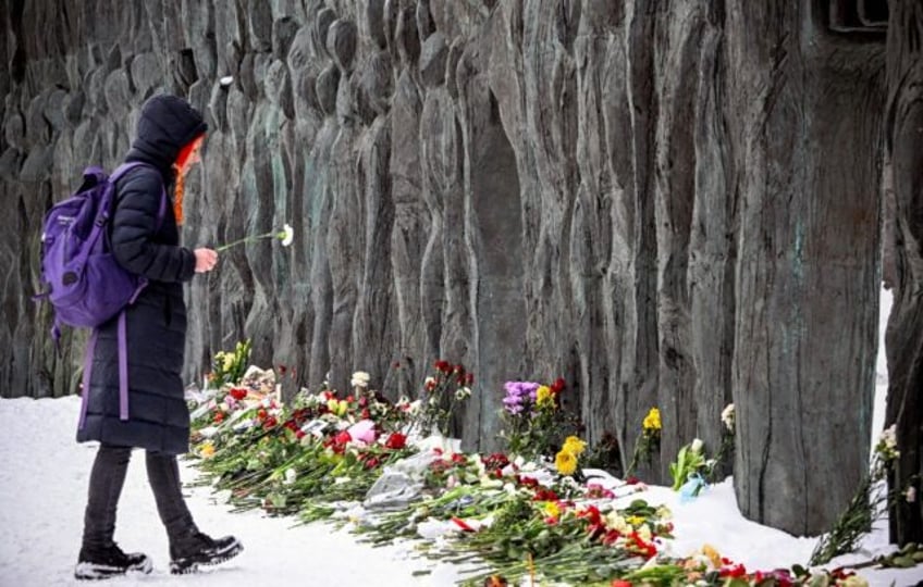 Some mourners gathered at a monument to victims of Soviet-era repression known as the 'Wal