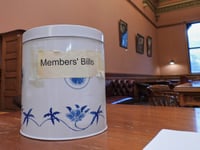 In New Zealand’s Parliament, a battered cookie tin decides which new laws get debated