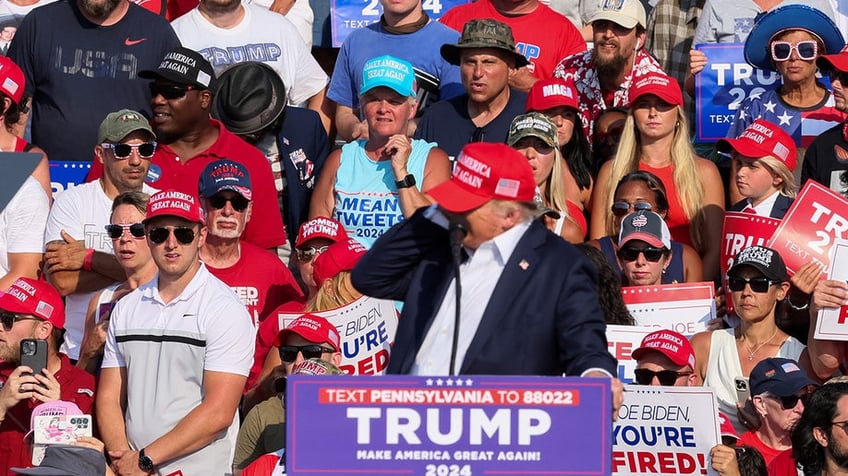 Donald Trump reacts as multiple shots rang out during a campaign rally