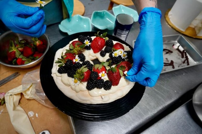 Annie Clemmons, owner of online bakery Chapman's DC, decorates an eggless pavlova in the g