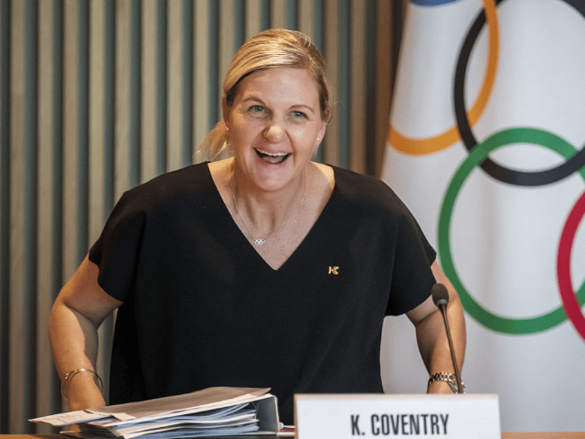 President of the International Olympic Committee Kirsty Coventry smiles seating or her fir