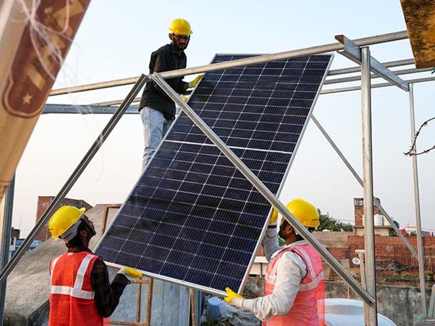 Indian solar installers install a rooftop ongrid solar panel system on a roof of a house i