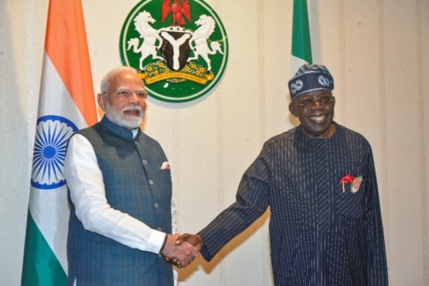 India's Prime Minister Narendra Modi (L) and Nigeria's President Bola Tinubu (R) are psuhi