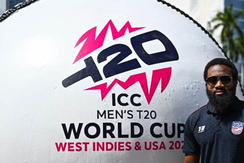 USA Cricket Vice-Captain Aaron Jones poses next to a giant cricket ball, installed at a ma