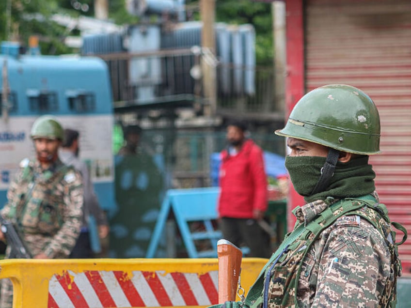 An Indian paramilitary soldier stands guard along a street in Srinagar, Jammu and Kashmir,