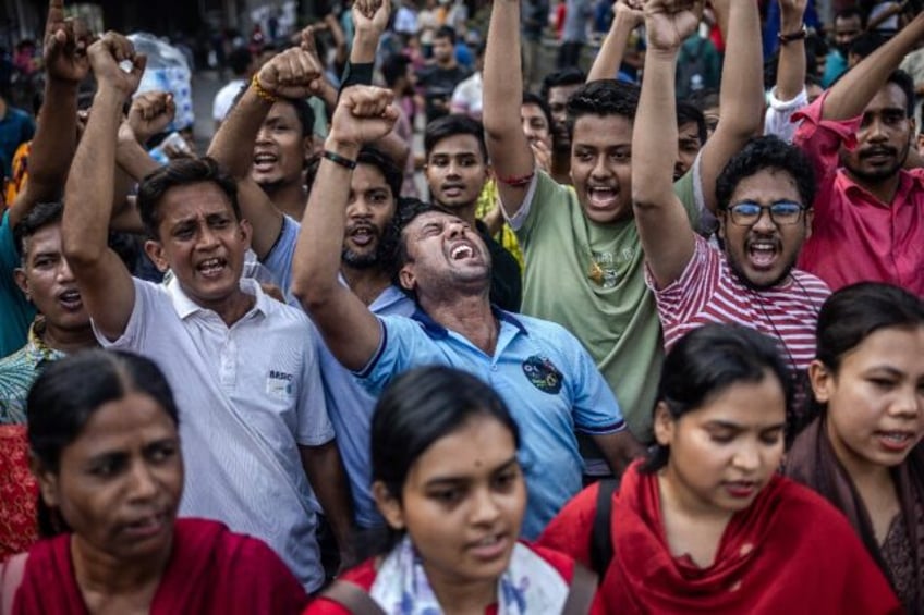 Members of the Bangladeshi Hindu community chant slogans against violence targeting the co