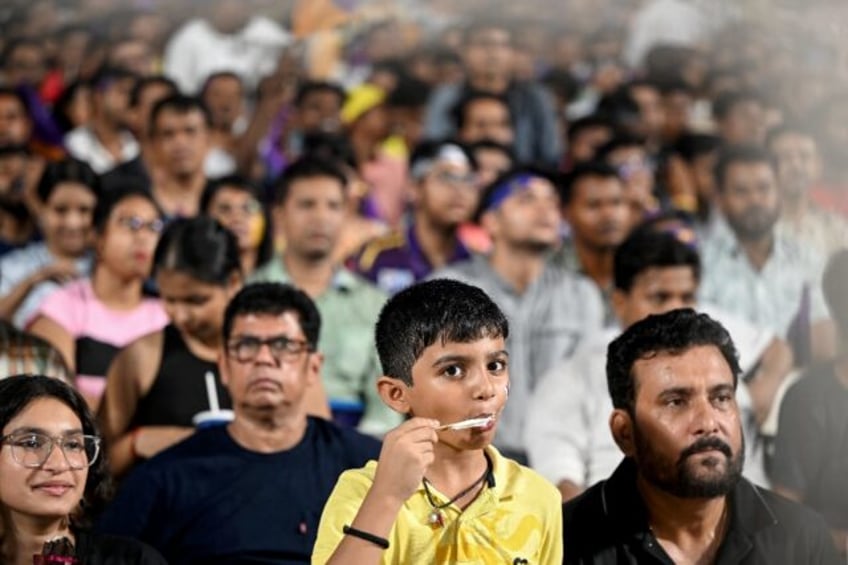 A young fan eats ice cream at a Kolkata Knight Riders match on Monday as a heatwave bakes