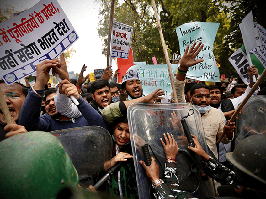 Security officers push back people shouting slogans during a protest held to show support to farmers who have been on a months-long protest, in New Delhi, India, Wednesday, Feb. 3, 2021. Nearly 200 supporters of Indian farmers on Wednesday clashed with the police who blocked them from marching to an area for protests close to Parliament in the Indian capital. Waving flags and banners representing their organizations, the protesters demanded the repeal of new agriculture reform laws which the farmers say will favor large corporate farms. (AP Photo/Manish Swarup)