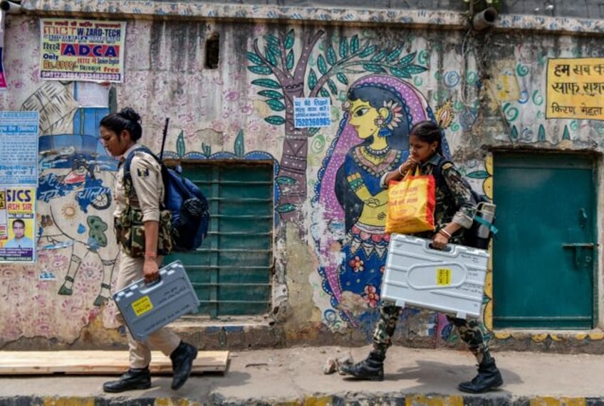 Security personnel carry electronic voting machines on May 31