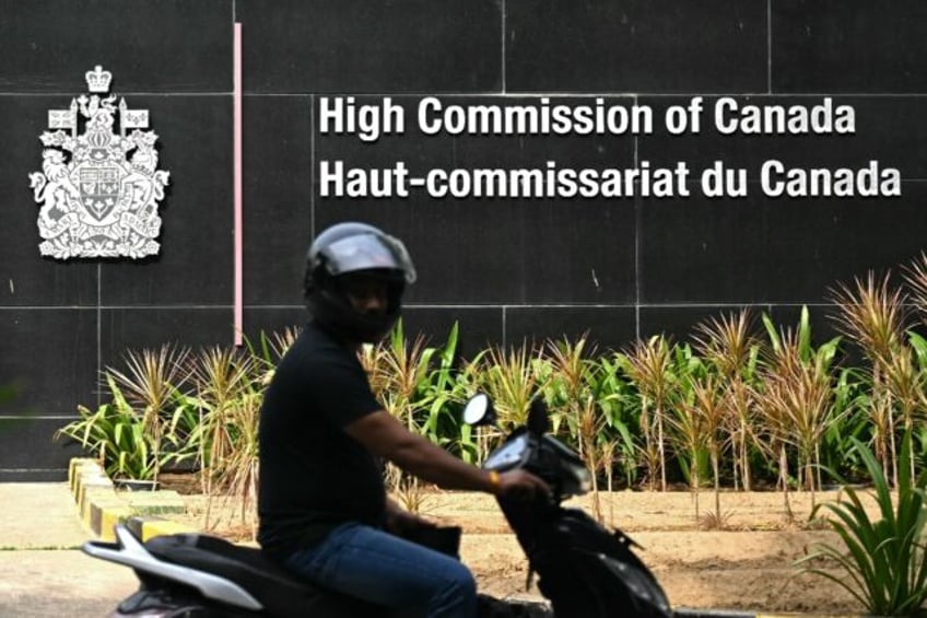 A motorist rides past the entrance of the Canadian High Commission in New Delhi