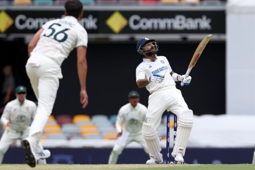 India's Virat Kohli (R) faces a bouncer from Australia's Mitchell Starc