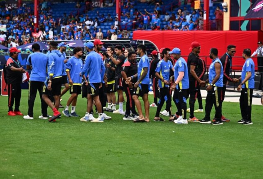 India and Canada team members shake hands after their T20 World Cup group A match was aban