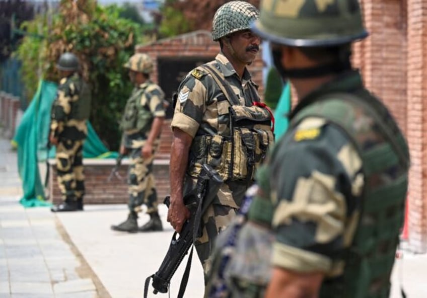 Indian forces stand guard on a street in Srinagar on Friday. Indian-administered Jammu and