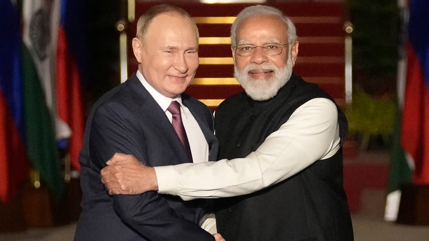 Russian President Putin and Indian Prime Minister Modi shake hands.