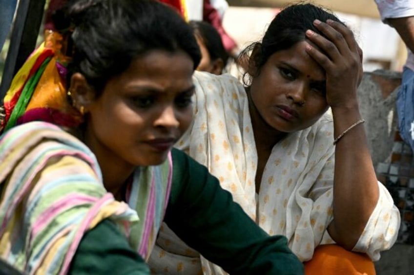 Mothers wait to identify the bodies of their children a day after a fire broke out at a ch