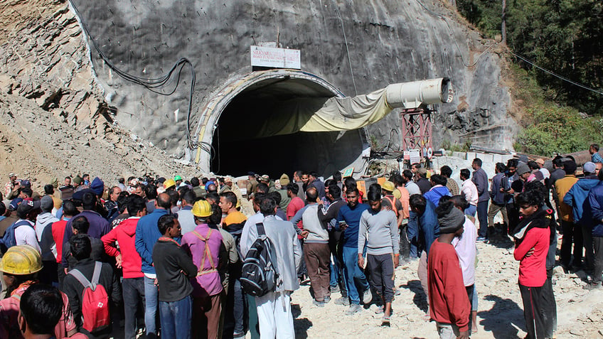 indian rescuers drill through rubble to reach workers trapped in collapsed tunnel