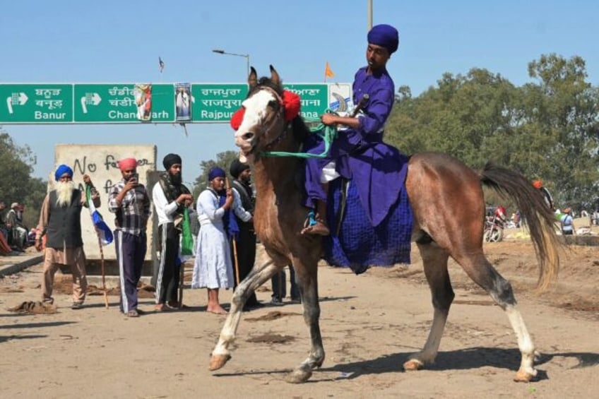 A Nihang, or a Sikh warrior, rides a horse during a farmers' to demand minimum crop prices