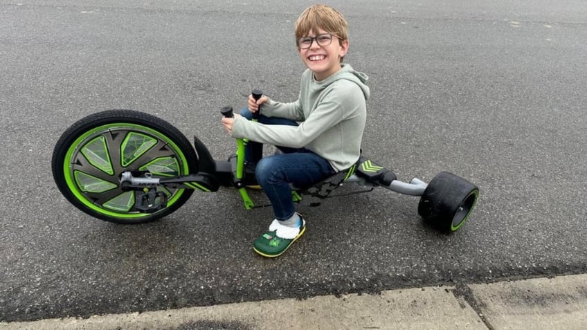 Sammy Teusch riding a tricycle