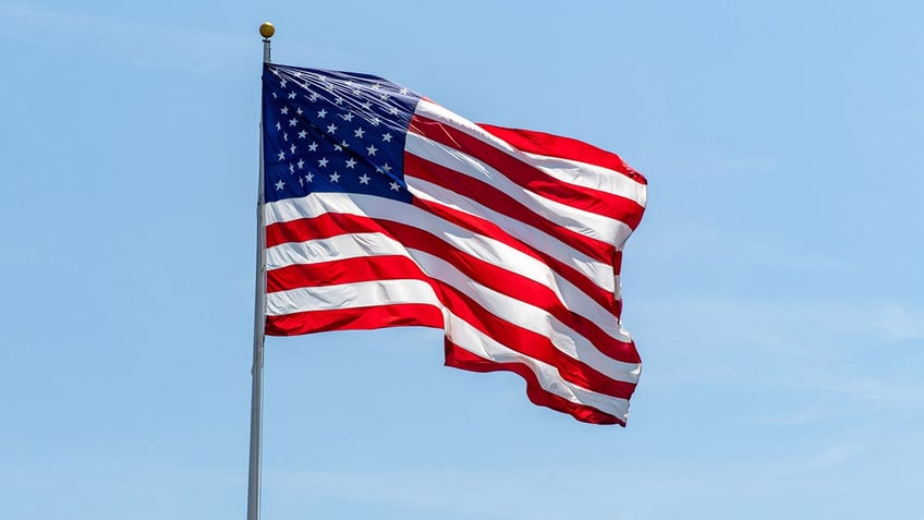 American flag waving in clear blue sky