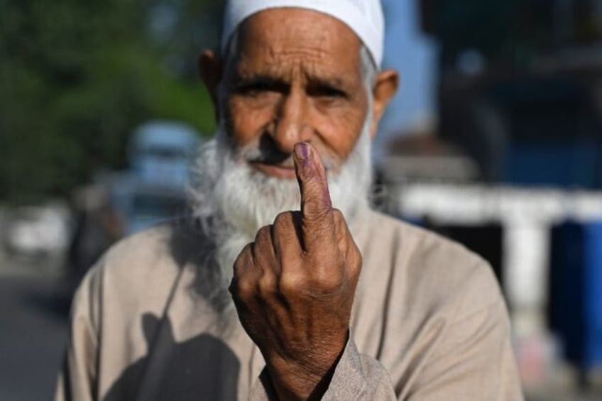 A voter shows his ink marked finger; many in the disputed Muslim-majority territory of 8.7